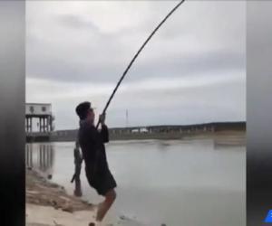 獨腳哥釣魚，被魚給拖著倒在地上，依舊要把魚釣上來
